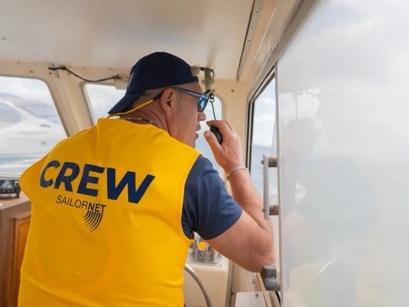Membro dell’equipaggio Sailornet con la pettorina CREW alla radio di bordo