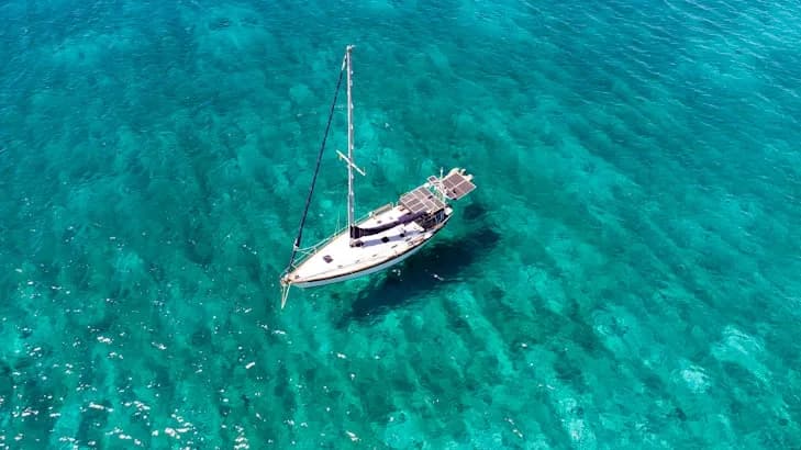 Veduta aerea di una barca a vela all’ancora su un fondale turchese