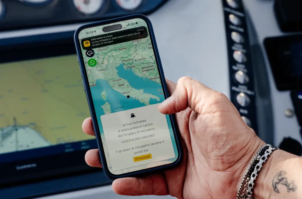 L’App Sailornet aperta sulla carta nautica, tenuta in mano a bordo di un’imbarcazione