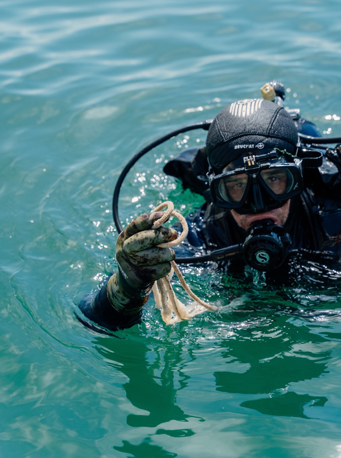 Sommozzatore Sailornet in acqua con una cima recuperata in mano