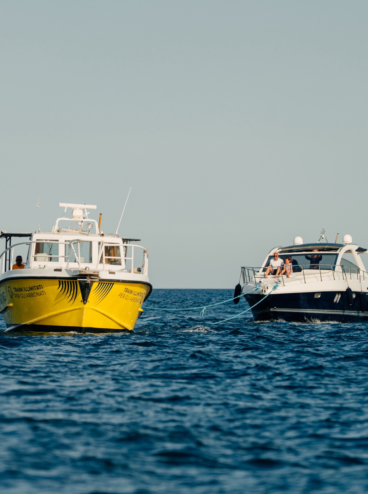 Motovedetta Sailornet che traina un’imbarcazione privata al tramonto